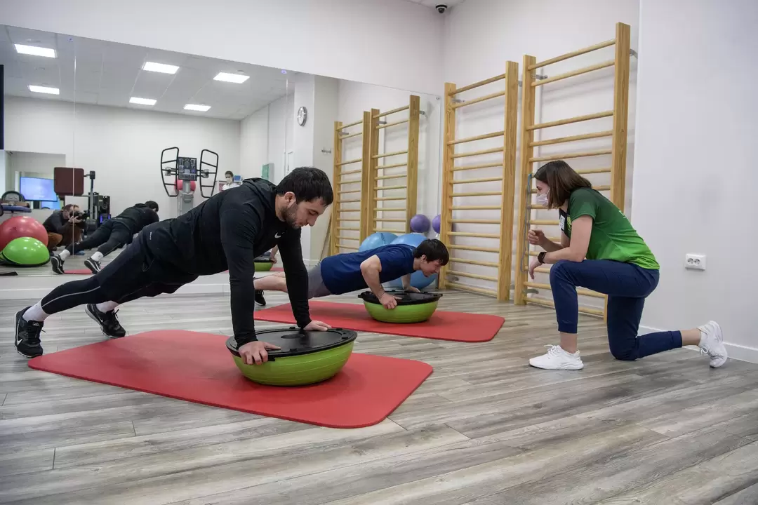 A rehabilitation therapist conducts exercise therapy with patients suffering from lower back pain